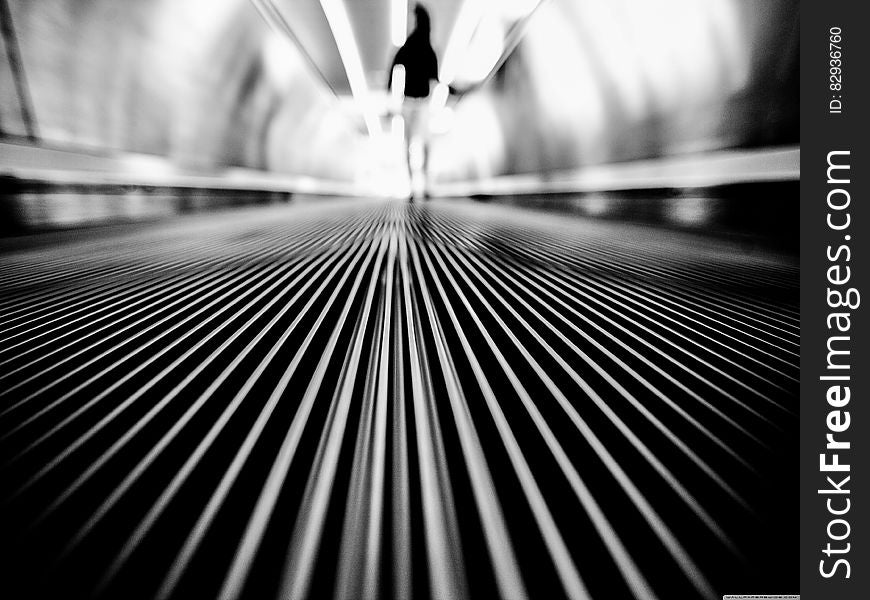 Greyscale Photography of Man Walking on Tunnel