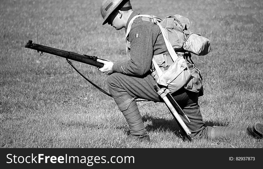 Man in Soldier Suit Holding Gun Knees Down in the Ground