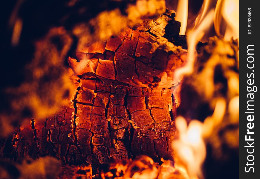 Background of fire with burning log beginning to disintegrate into small square glowing pieces, hot orange and white flames everywhere. Background of fire with burning log beginning to disintegrate into small square glowing pieces, hot orange and white flames everywhere.