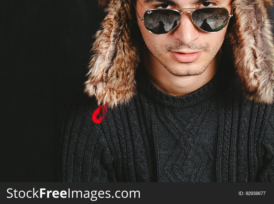 A man wearing a fur hat and sunglasses. A man wearing a fur hat and sunglasses.