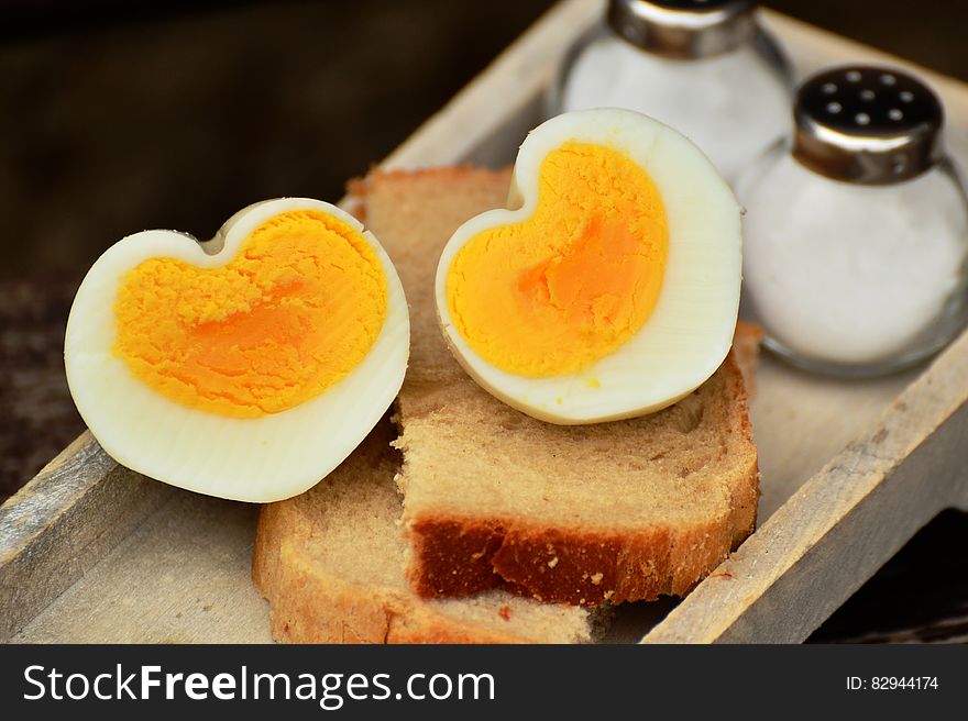Boiled Egg on Top on Bread Beside Salt Shaker