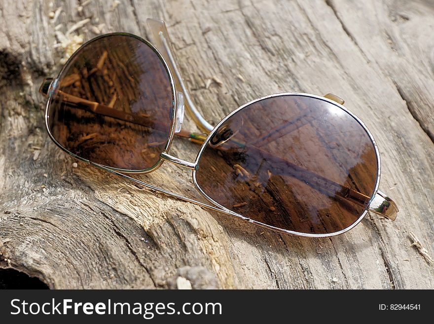 Silver Aviator Sunglasses on Top of Wooden Surface