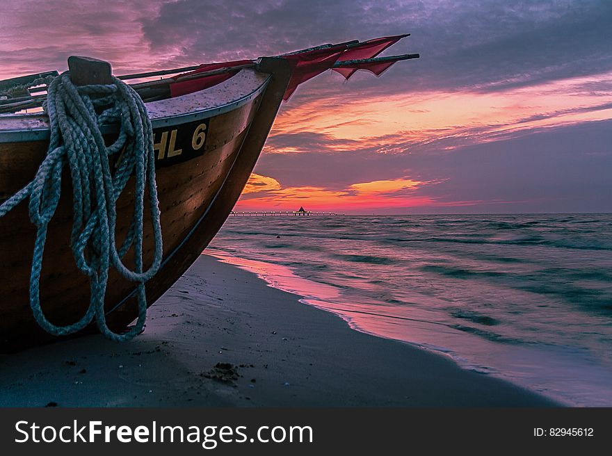 Brown Wooden Boat on Shore during Sunset