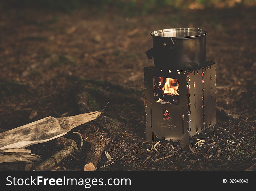 Stainless Steel Pot on Brown Wood Stove Outside during Night Time