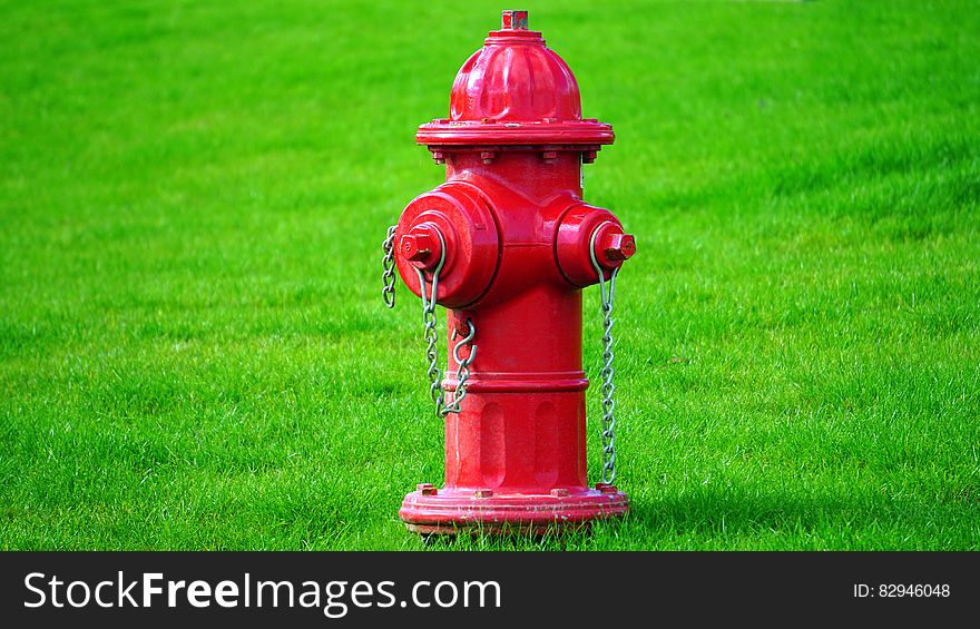 Red Fire Hydrant on Green Grass Field