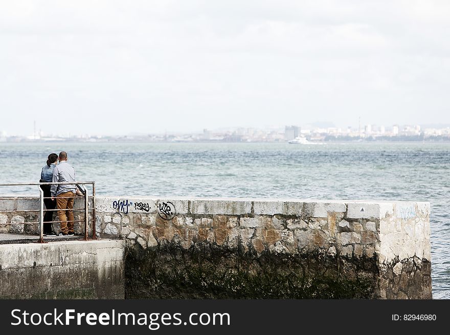 Man And Woman Standing Beside Dock Under Daylight