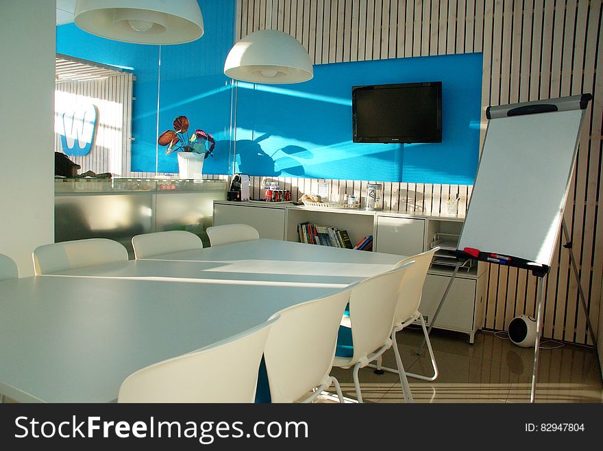 A contemporary meeting or conference room in office with table and whiteboard. A contemporary meeting or conference room in office with table and whiteboard.