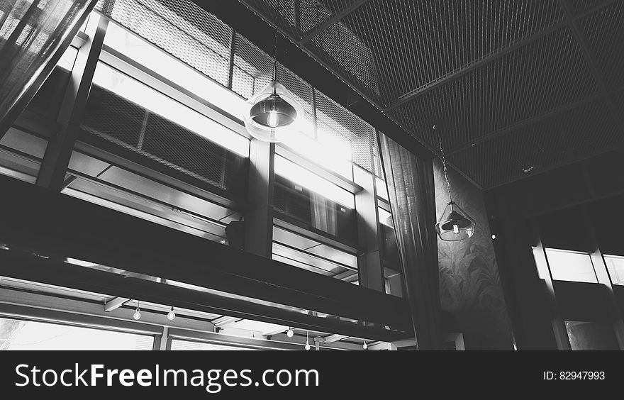 Grayscale Photo of Hanged Ceiling Lamp Inside the Building