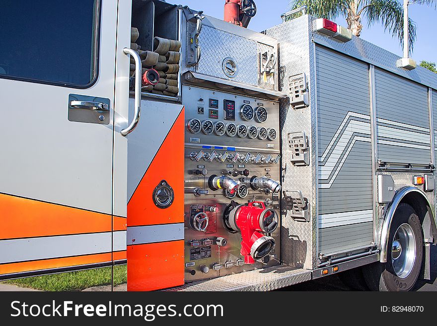 Close up of gauges and knobs on exterior control panel of modern fire engine on sunny day. Close up of gauges and knobs on exterior control panel of modern fire engine on sunny day.