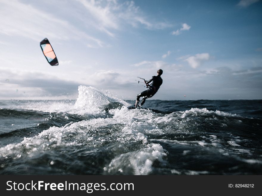 Kitesurfing in blue waters on sunny day.