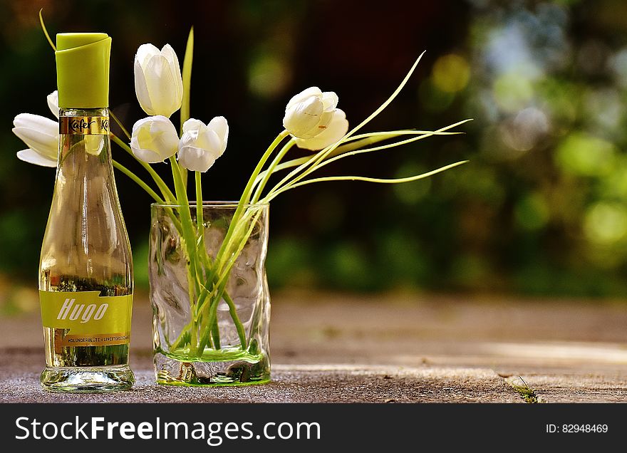 Clear Glass Hugo Bottle With White Flowers