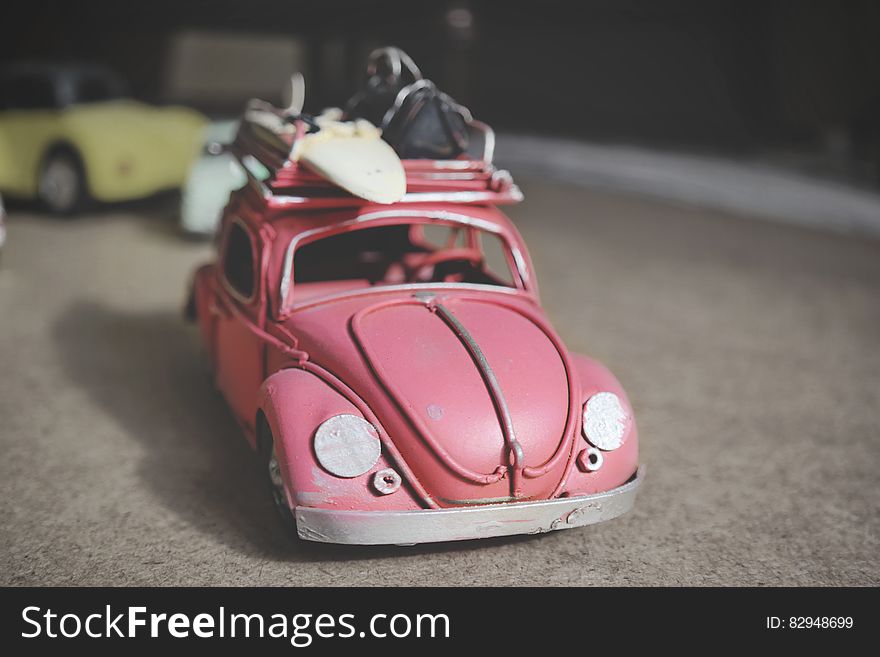 Vintage toy pink Volkswagen Beetle car with surf board. Vintage toy pink Volkswagen Beetle car with surf board