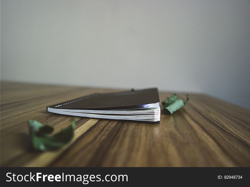 Black Small Notebook on Brown Wooden Surface