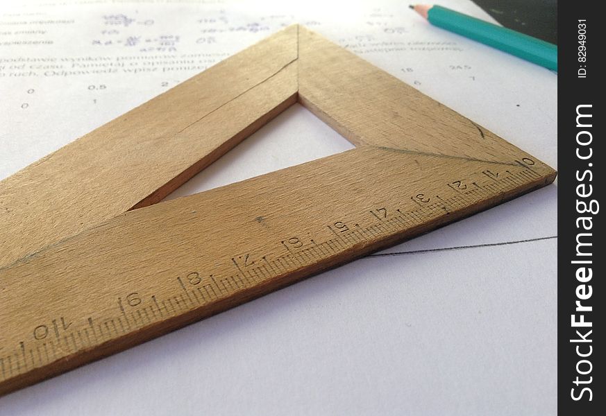 Still life of geometry homework sheet with wooden measuring stick and pencil.