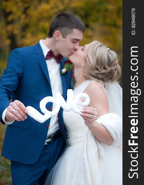 Newly Wed Couple Kissed Each Other While Holding Love Cutout