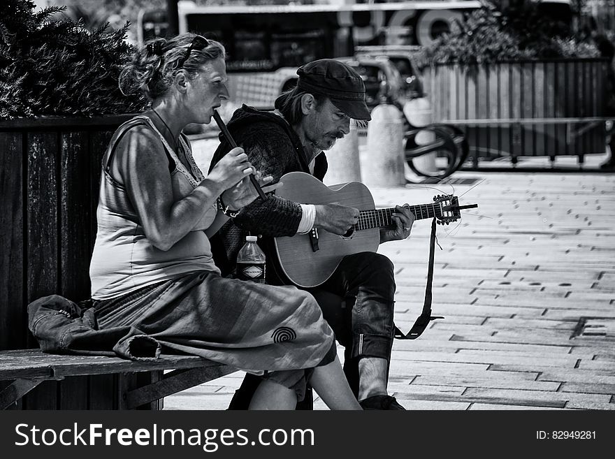 Greyscale Photography of Man and Woman Playing Musical Instruments