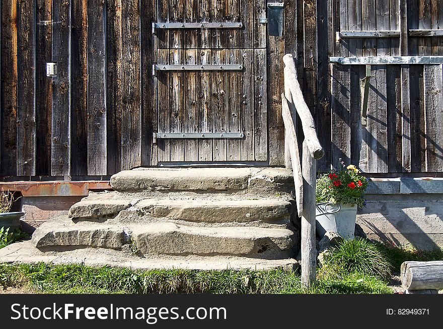 Stone steps leading to worn wooden door outside house on sunny day. Stone steps leading to worn wooden door outside house on sunny day.