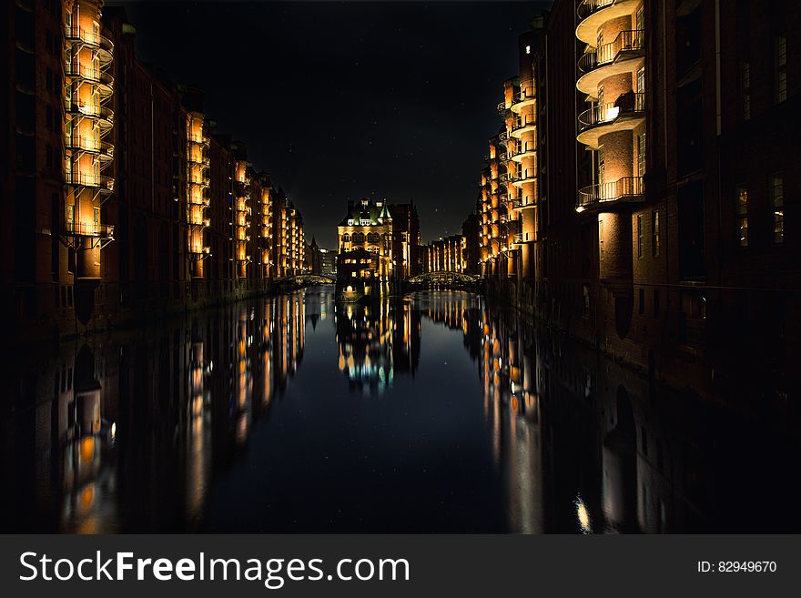 Reflection Of Buildings On Water During Nighttime