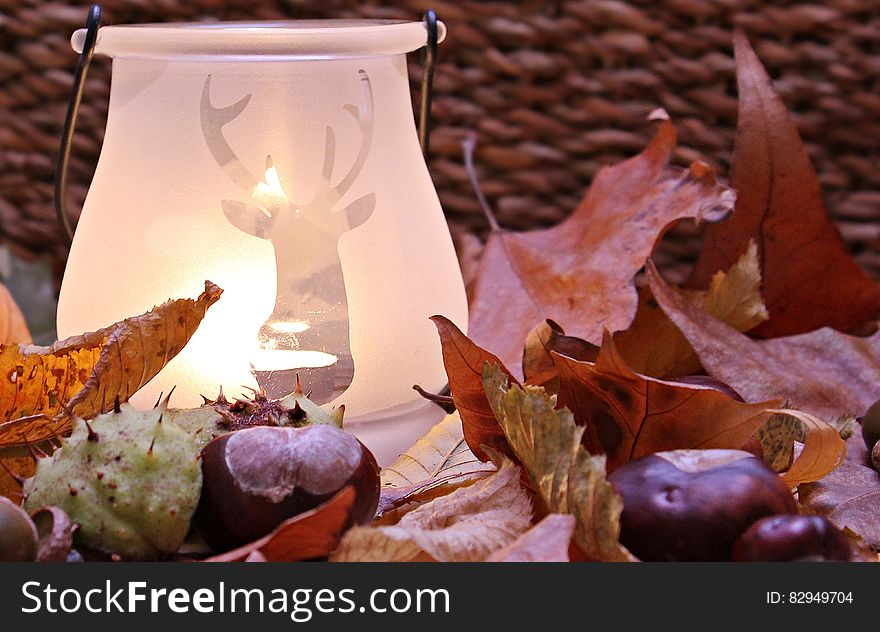 White Ceramic Lamp With Deer Cutout Near Leaves