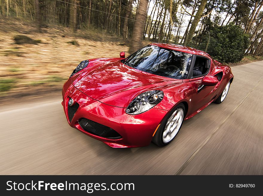 Red sports car on forest road