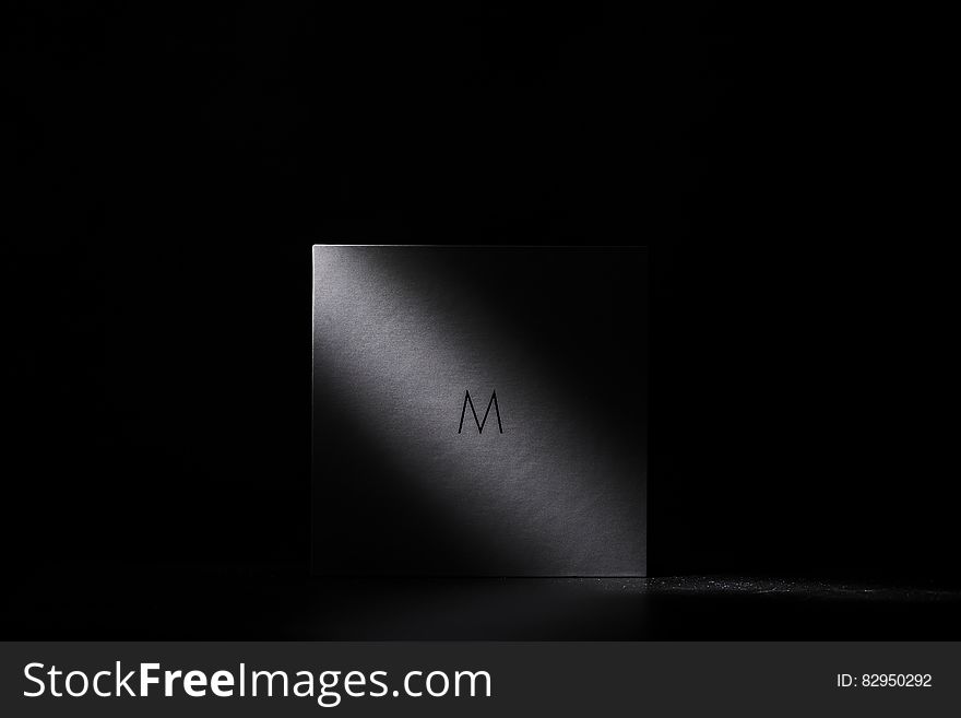Abstract white square bathed in light with black background and copy space.