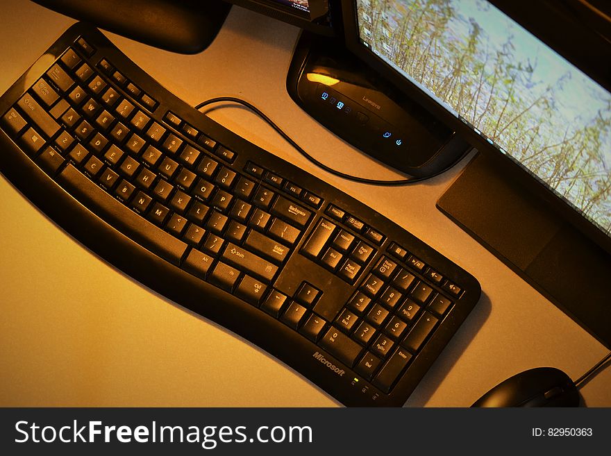 Desktop computer with keyboard, mouse, amplifier and wide screen with map details displayed, yellow background.