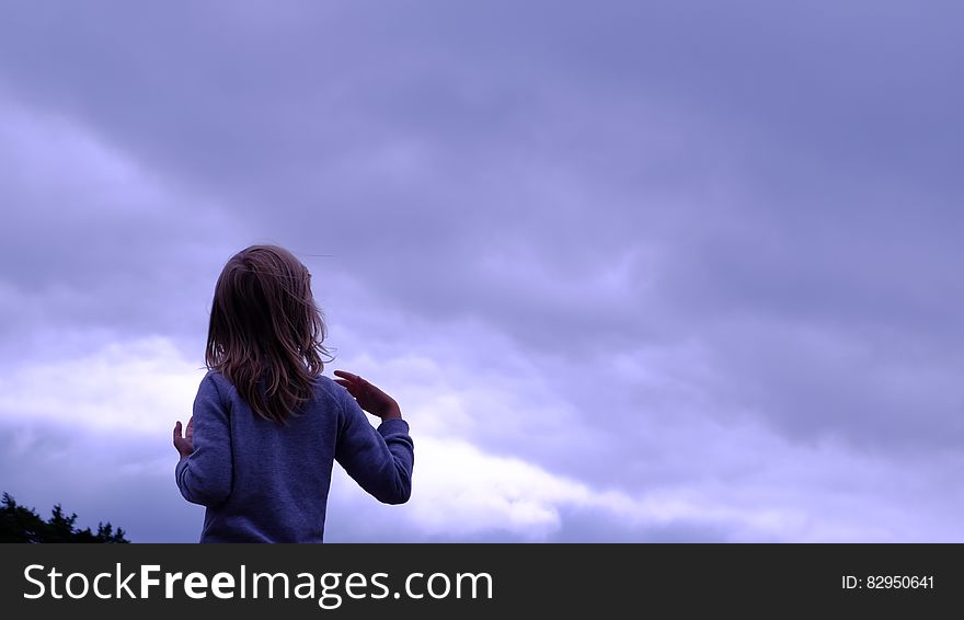 Woman in Blue Sweater Facing in Blue Clear Sky