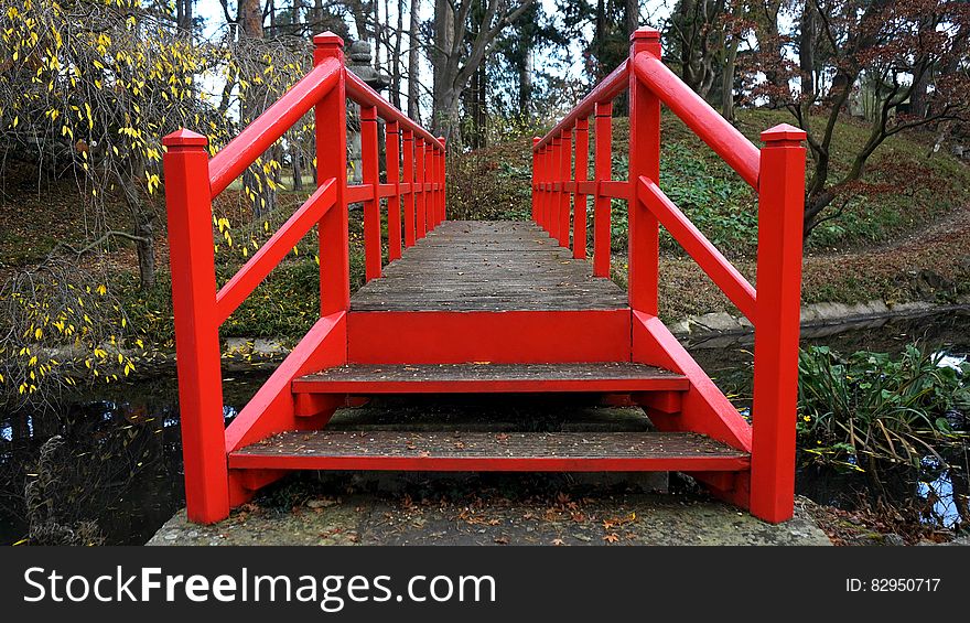 Red wooden bridge in sunny garden woods. Red wooden bridge in sunny garden woods.