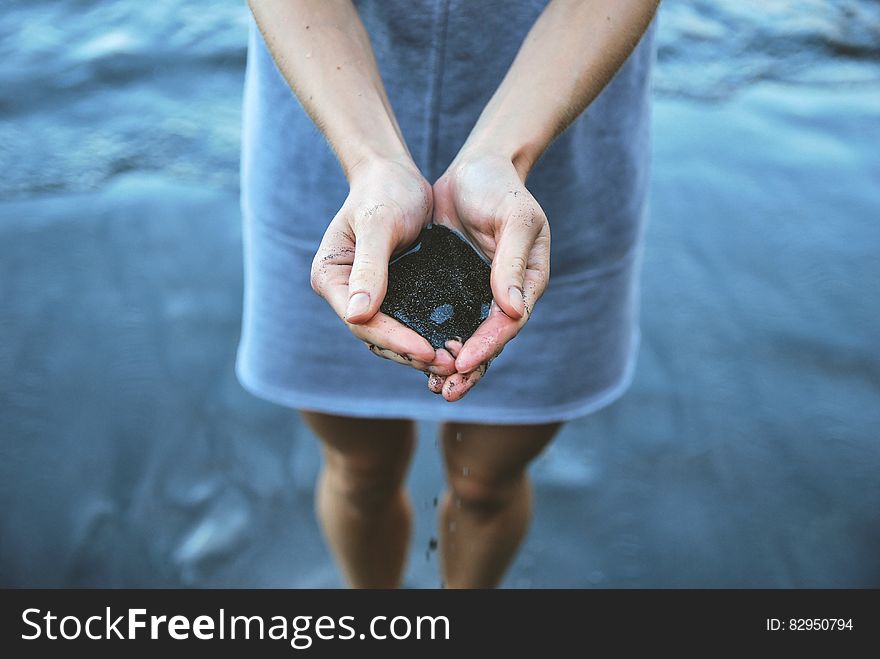 Woman holding sand at beach