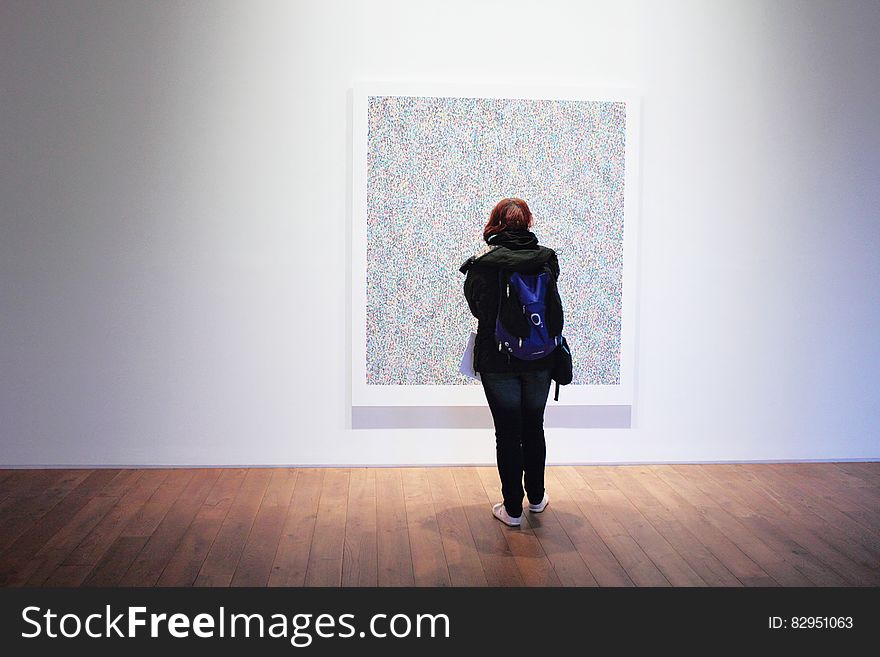 Woman Standing Infront of a Wall Mount Painting