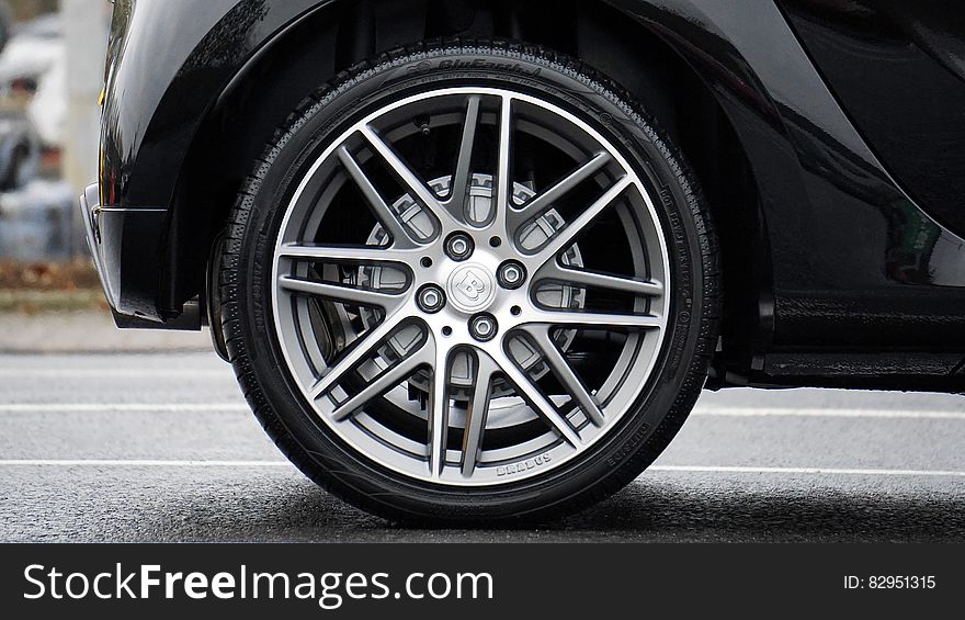 Close up of wheel and tire on black car on streets. Close up of wheel and tire on black car on streets.