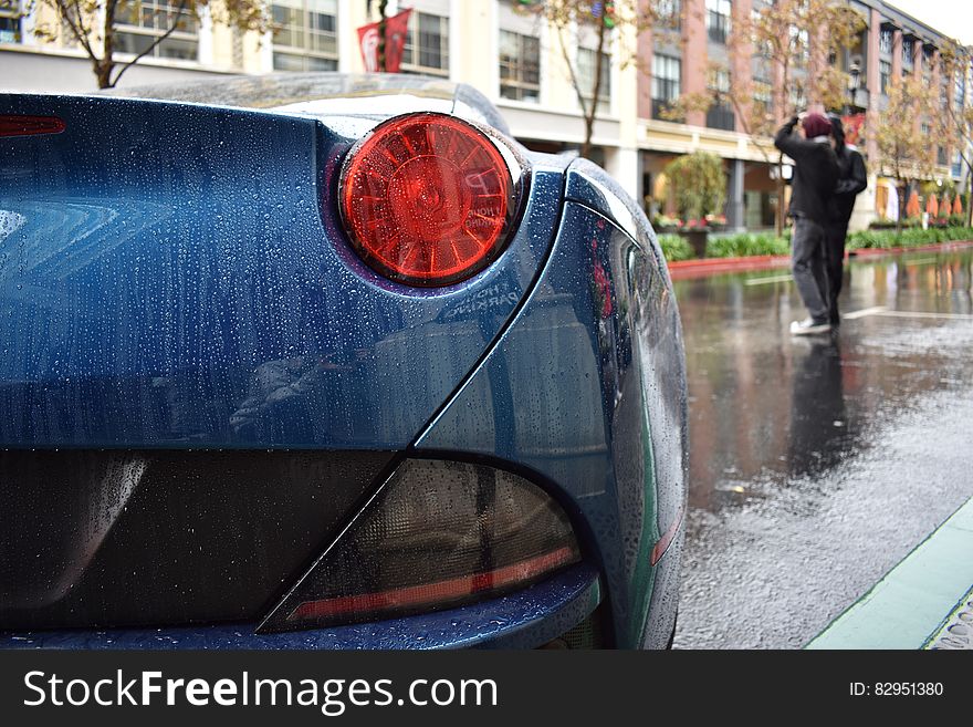 Taillight of blue sports car on streets in rain. Taillight of blue sports car on streets in rain.