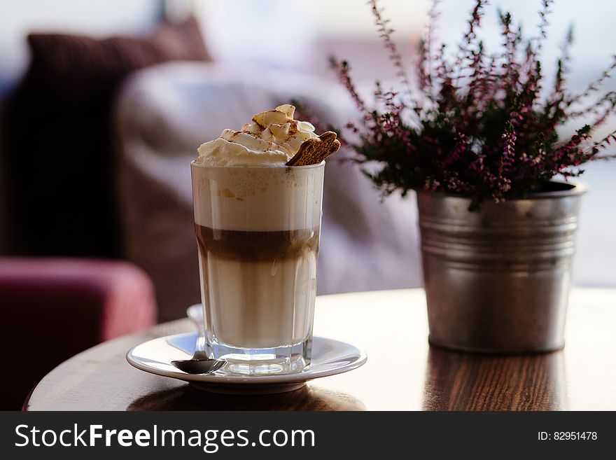 Ice Cream In Glass Beside Maroon Petaled Flower On Vase On Table