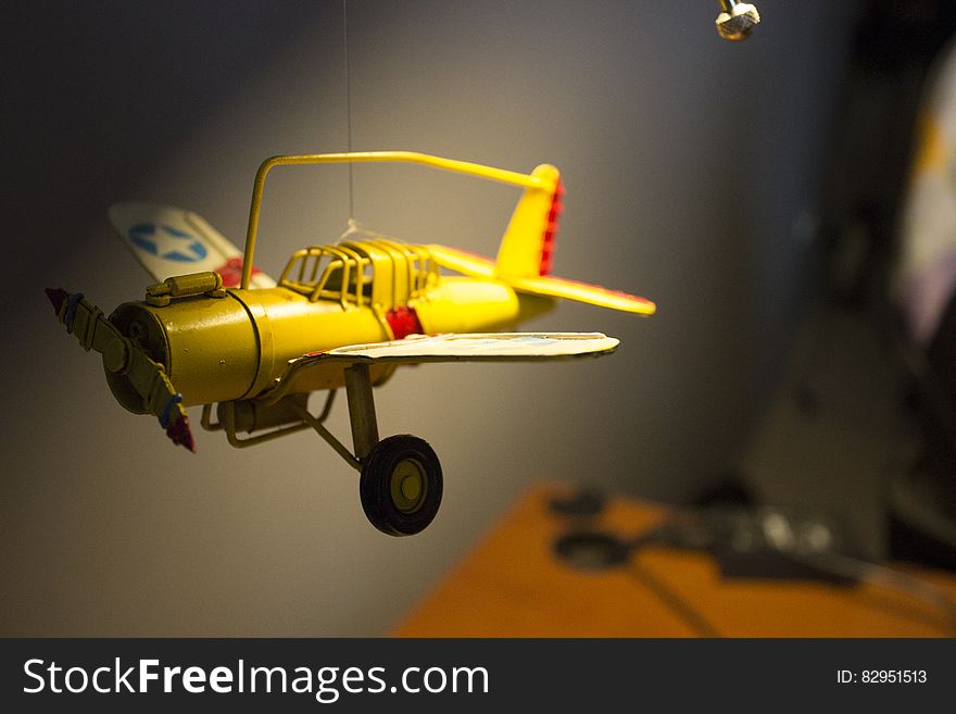 Yellow single seat propeller driven model aeroplane with undercarriage down and blue and yellow star on the wings. Yellow single seat propeller driven model aeroplane with undercarriage down and blue and yellow star on the wings.