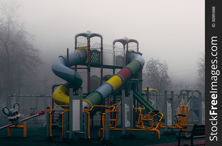 Colorful slide and rides in playground on foggy day. Colorful slide and rides in playground on foggy day.