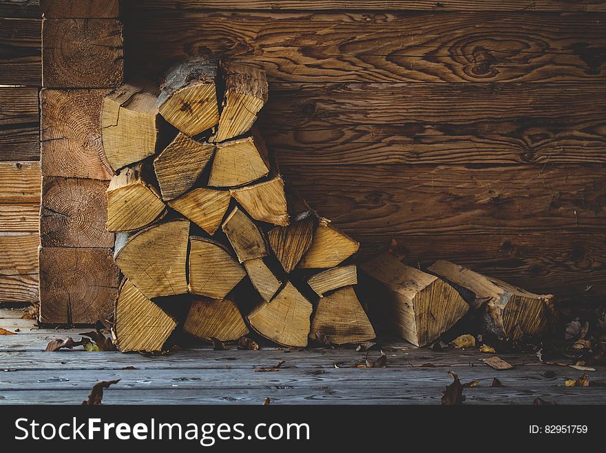 Stack of firewood against wooden wall on boards. Stack of firewood against wooden wall on boards.