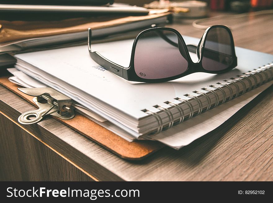 Black Frame Wayfarer Sunglasses on White Notebook