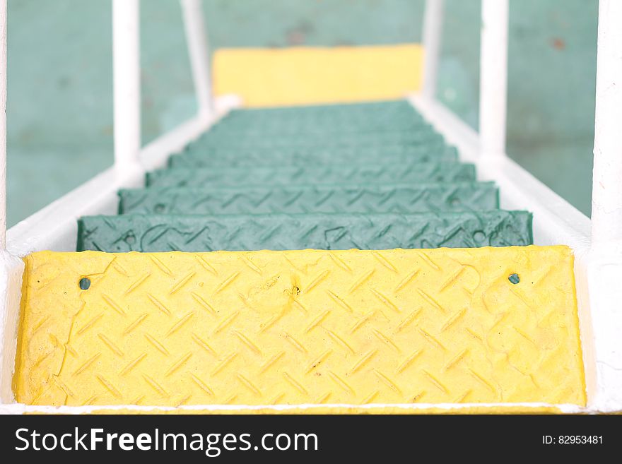 Flight of green metal stairs, only first and last yellow. Flight of green metal stairs, only first and last yellow.