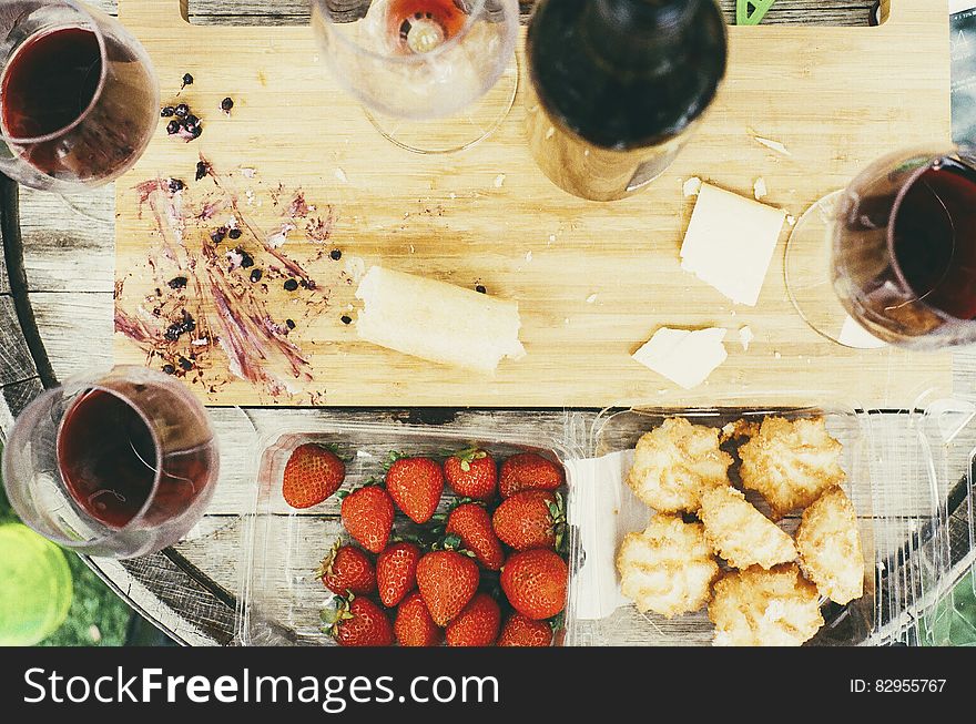 Glasses of red wine with strawberries and cookies on wooden tabletop. Glasses of red wine with strawberries and cookies on wooden tabletop.