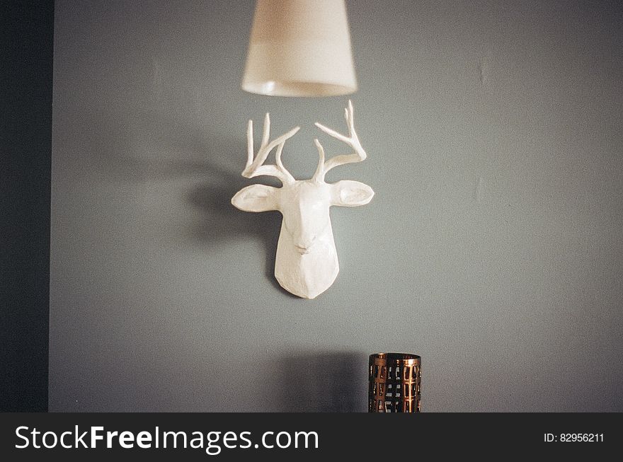 A white ceramic deer head as wall decoration.