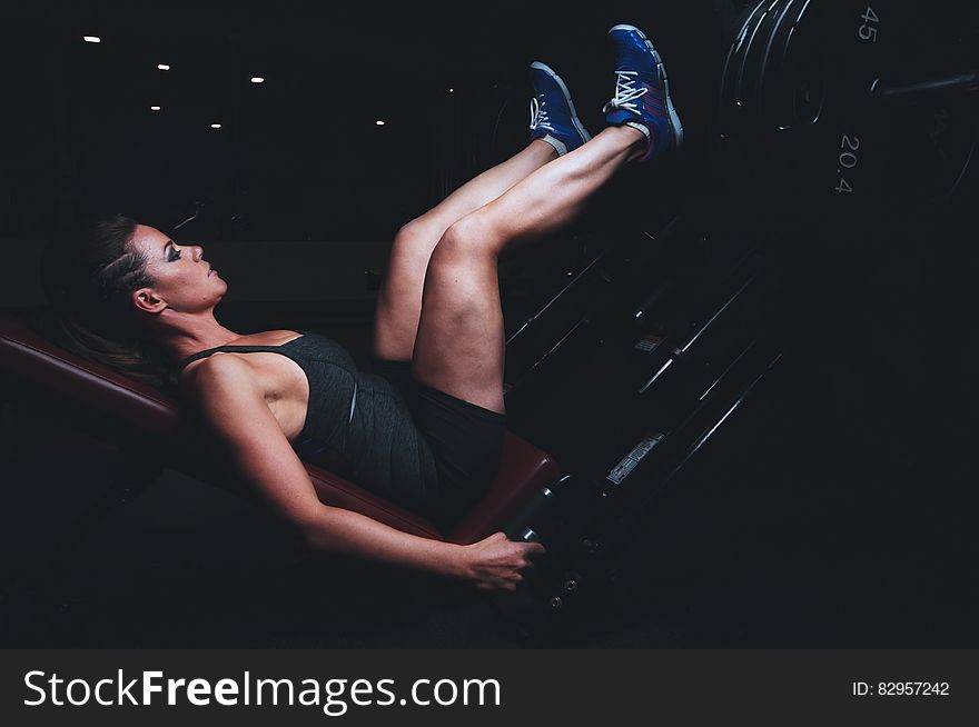 Portrait of woman training in dark gym. Portrait of woman training in dark gym.