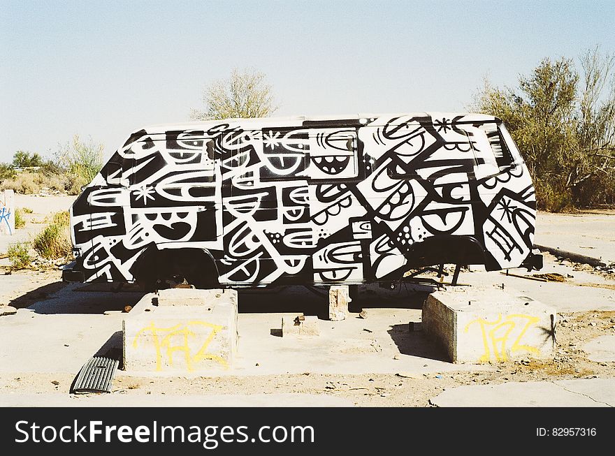 Graffiti on old van parked in desert.