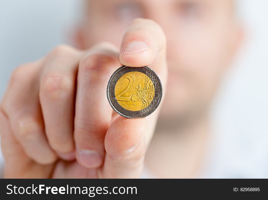 Person Holding a Gold and Silver Round Coin