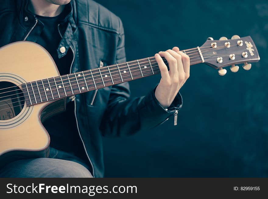 Close up of musician holding and playing acoustic guitar. Close up of musician holding and playing acoustic guitar.