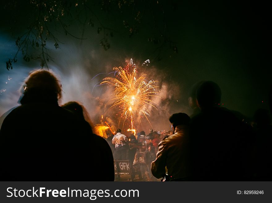 Silhouette of people outdoors watching fireworks display in sky. Silhouette of people outdoors watching fireworks display in sky.