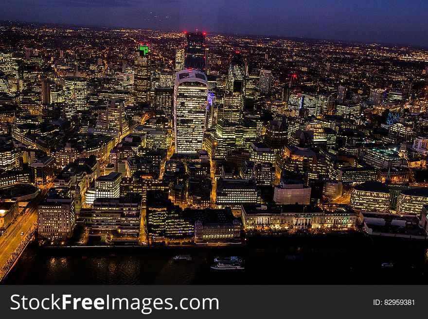 Aerial view of city skyline illuminated at night.