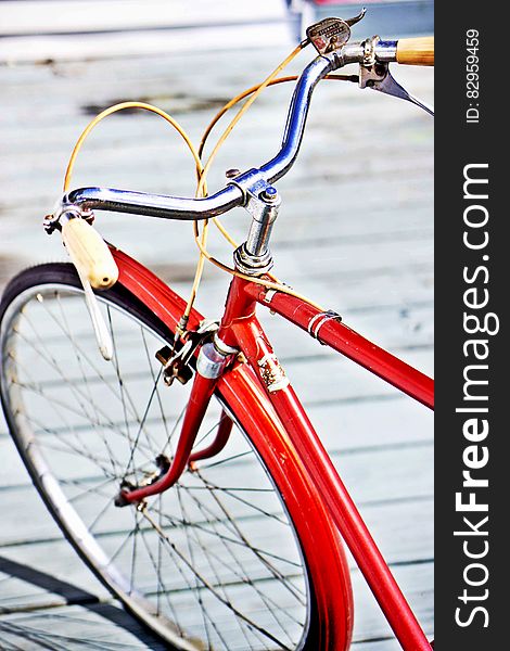 Close up of front fender, tire and handlebars on bicycle on boardwalk outdoors. Close up of front fender, tire and handlebars on bicycle on boardwalk outdoors.