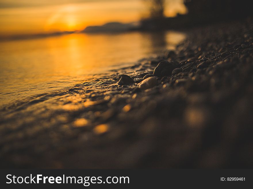 Close up of pebbles on beach at sunset. Close up of pebbles on beach at sunset.