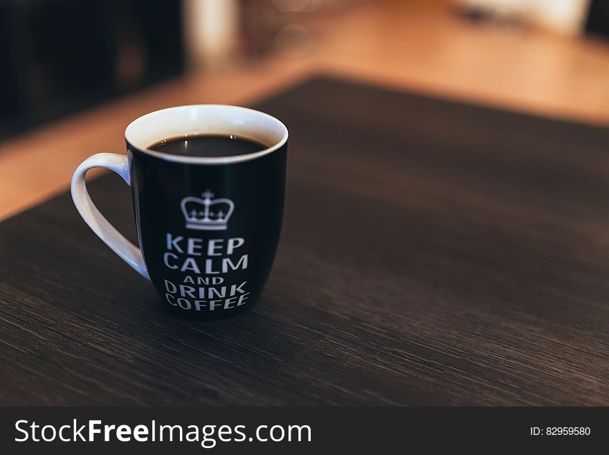 Black And White Ceramic Mug On Wooden Table