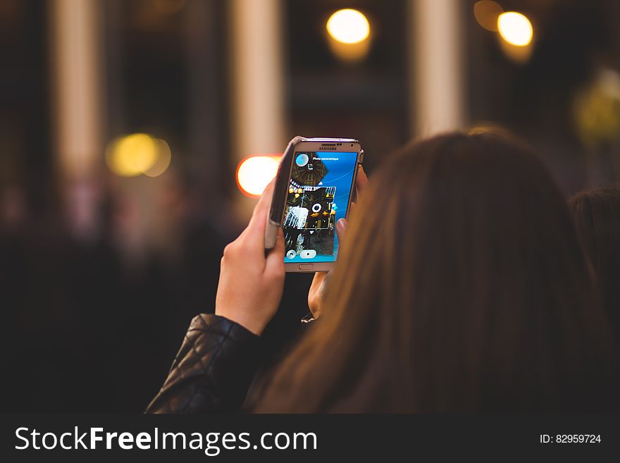 Girl using smartphone app on urban streets at night. Girl using smartphone app on urban streets at night.